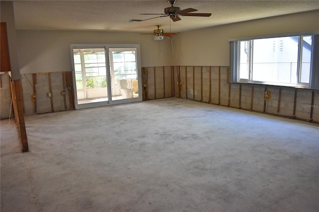 unfurnished room with light carpet, plenty of natural light, and a textured ceiling