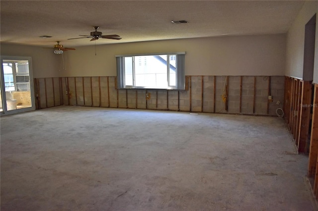 spare room featuring light carpet, a textured ceiling, and ceiling fan