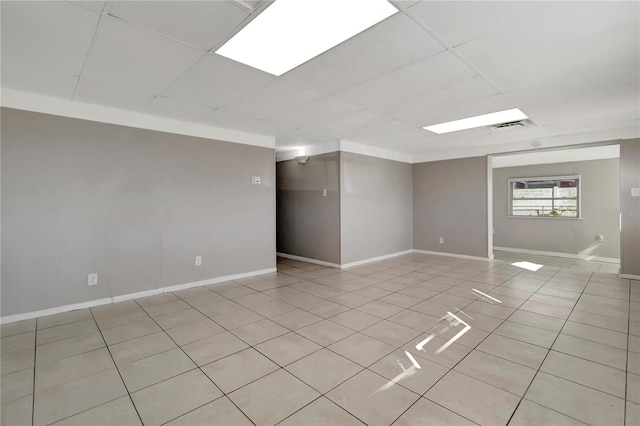 tiled spare room with a drop ceiling