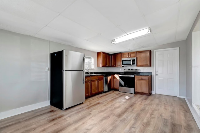 kitchen with sink, stainless steel appliances, and light hardwood / wood-style flooring