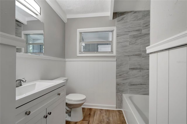 bathroom featuring hardwood / wood-style flooring, vanity, toilet, and a textured ceiling