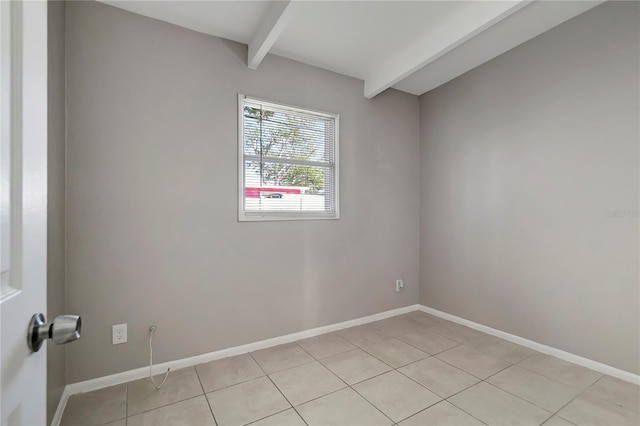 unfurnished room featuring beam ceiling and light tile patterned floors