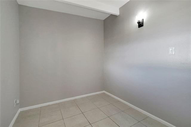 tiled spare room with beam ceiling