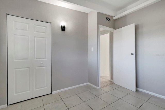 unfurnished bedroom with a closet and light tile patterned flooring