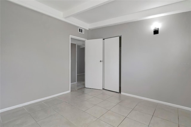 tiled spare room with beam ceiling