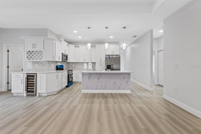 kitchen featuring wine cooler, light hardwood / wood-style floors, pendant lighting, white cabinets, and appliances with stainless steel finishes