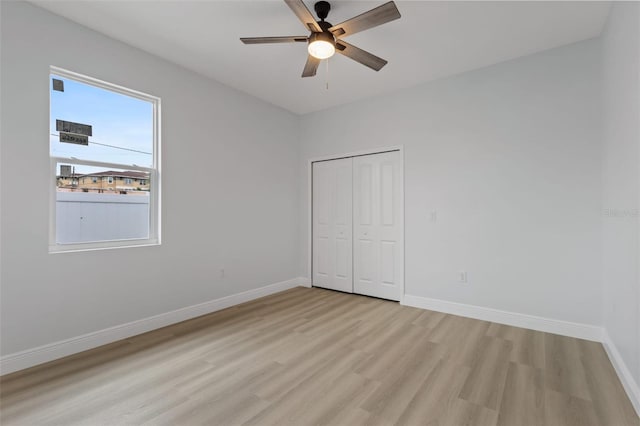 unfurnished bedroom featuring ceiling fan, a closet, and light hardwood / wood-style flooring