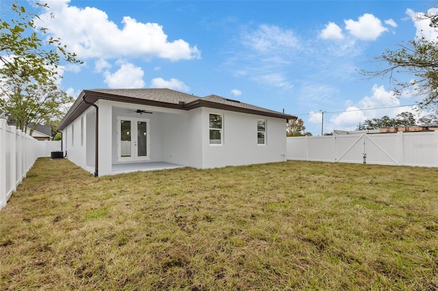 rear view of property with a lawn, a patio area, and ceiling fan