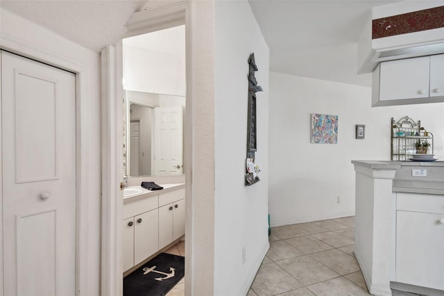 hall with light tile patterned flooring and sink