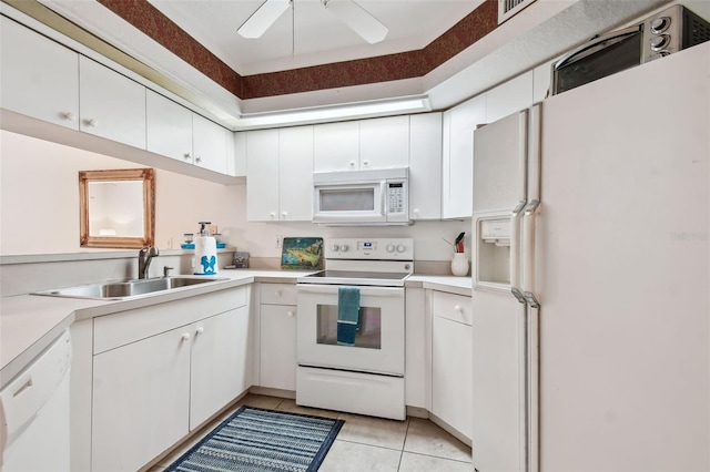 kitchen with white cabinets, light tile patterned floors, white appliances, and sink