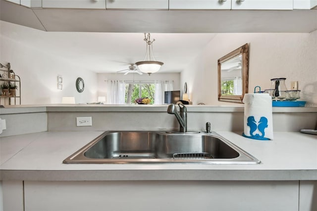 kitchen with sink, white cabinets, and decorative light fixtures