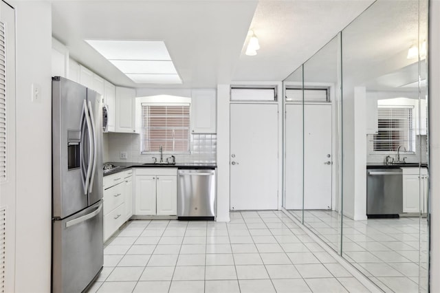 kitchen with white cabinets, backsplash, sink, and appliances with stainless steel finishes