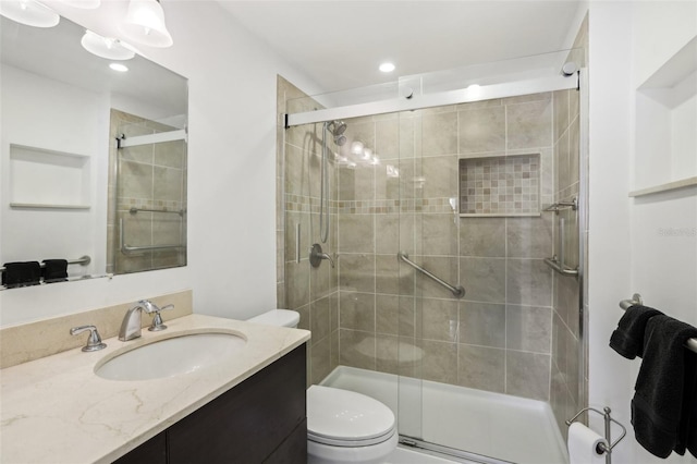 bathroom with vanity, toilet, and a shower with door