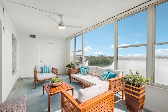 sunroom / solarium with a water view and ceiling fan