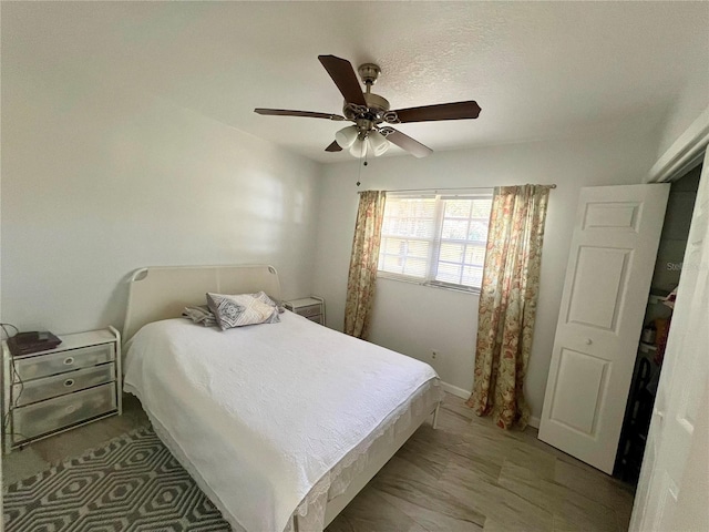 bedroom with ceiling fan and a textured ceiling