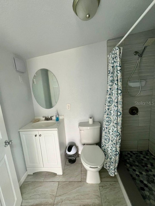 bathroom featuring a shower with shower curtain, vanity, toilet, and a textured ceiling