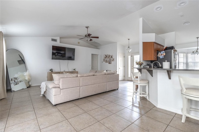 tiled living room featuring ceiling fan, sink, and lofted ceiling