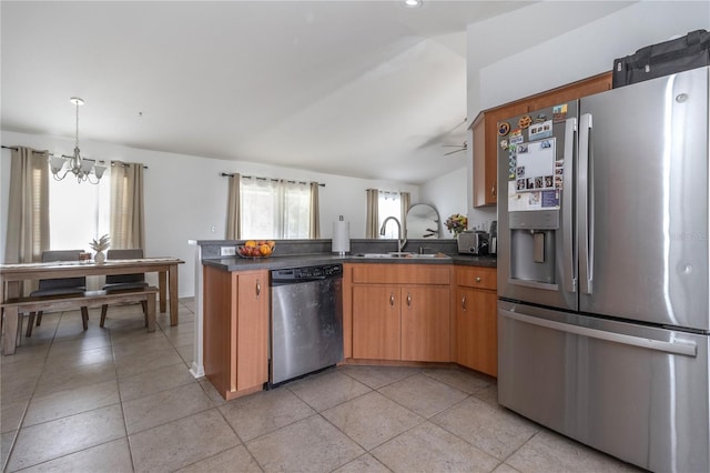 kitchen featuring appliances with stainless steel finishes, a wealth of natural light, a notable chandelier, and sink