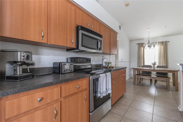 kitchen with appliances with stainless steel finishes, vaulted ceiling, pendant lighting, light tile patterned floors, and a notable chandelier