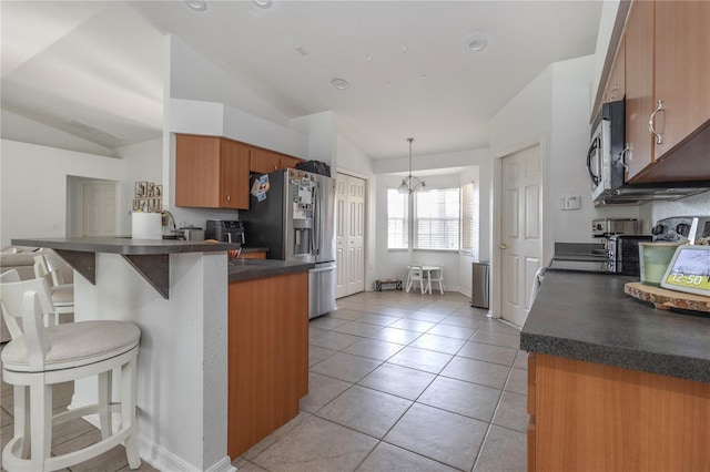 kitchen with a kitchen breakfast bar, hanging light fixtures, vaulted ceiling, kitchen peninsula, and stainless steel appliances