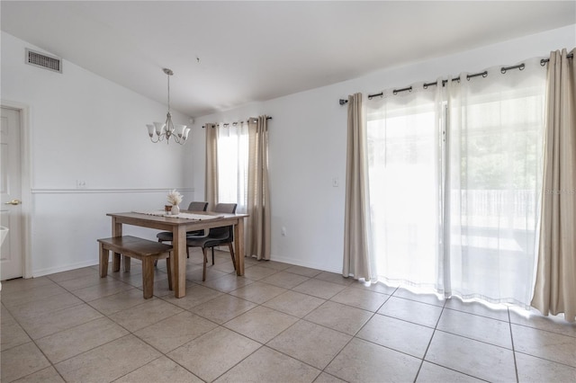 tiled dining area featuring a chandelier and vaulted ceiling