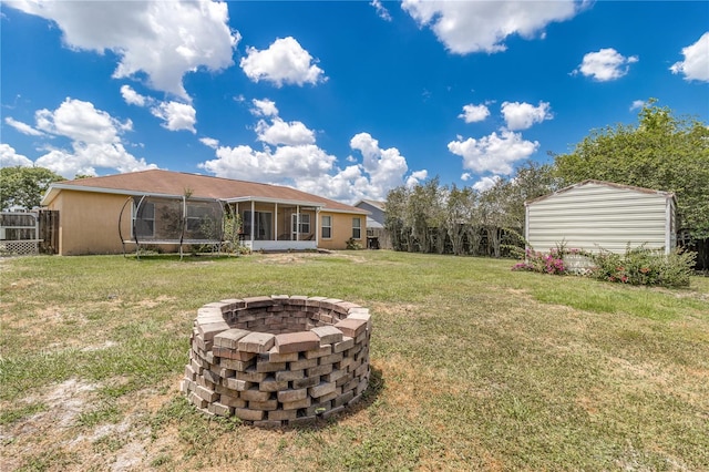 view of yard featuring a sunroom and a fire pit