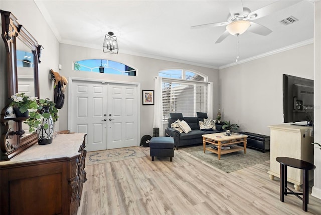 living room featuring light hardwood / wood-style flooring, ceiling fan, and crown molding