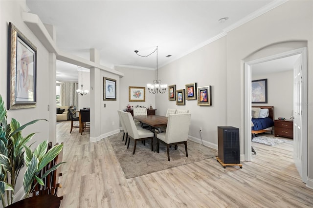 dining room with a notable chandelier, light hardwood / wood-style floors, and crown molding