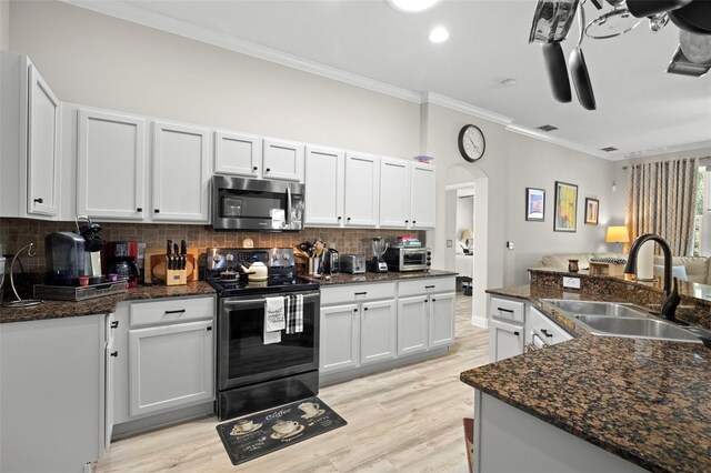 kitchen with white cabinets, dark stone countertops, black range with electric stovetop, and sink