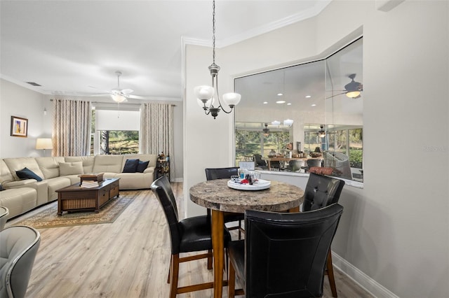 dining space with hardwood / wood-style floors, ceiling fan with notable chandelier, and ornamental molding