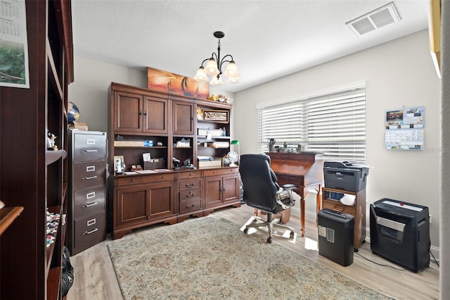 home office featuring an inviting chandelier and light hardwood / wood-style flooring