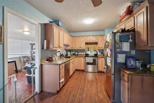 kitchen featuring light brown cabinets, a textured ceiling, stainless steel appliances, and dark hardwood / wood-style floors