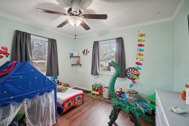 bedroom featuring hardwood / wood-style floors, a textured ceiling, ceiling fan, and ornamental molding