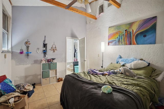 tiled bedroom featuring vaulted ceiling with beams and ceiling fan