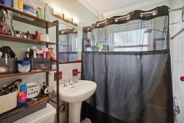 full bathroom with sink, shower / bathtub combination with curtain, a textured ceiling, tile walls, and ornamental molding