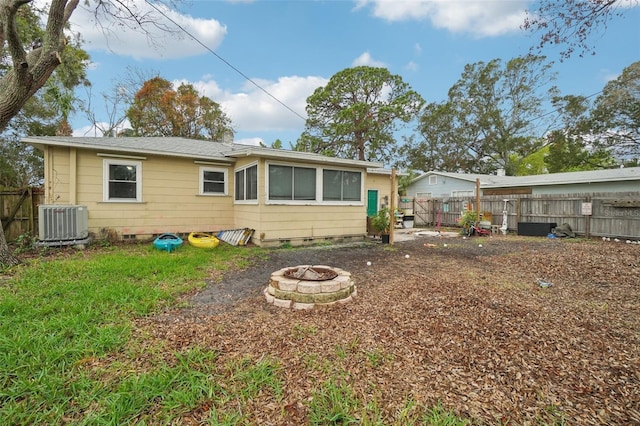 rear view of house featuring central AC unit and an outdoor fire pit