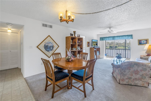 dining room featuring ceiling fan with notable chandelier, a textured ceiling, and light carpet