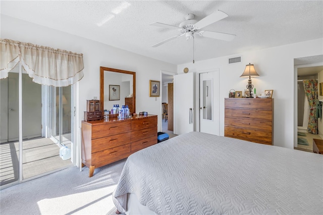 bedroom with ceiling fan, carpet floors, and a textured ceiling