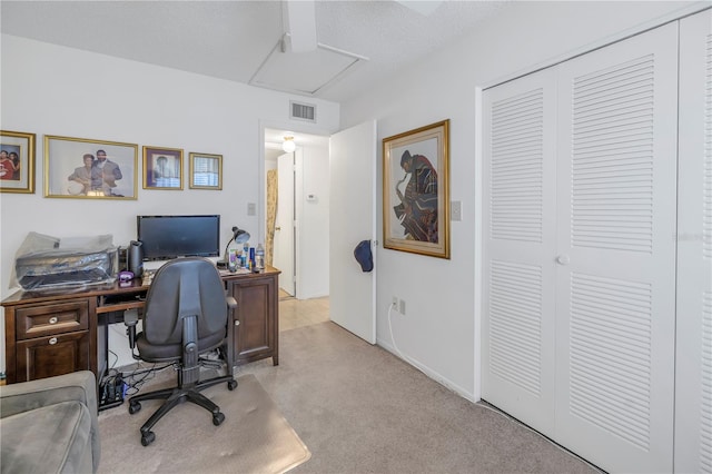 office with a textured ceiling and light colored carpet