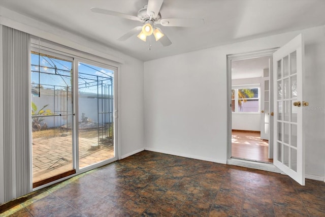 empty room featuring french doors, a wealth of natural light, and ceiling fan