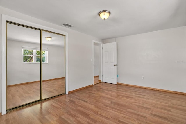 unfurnished bedroom with a closet and light hardwood / wood-style flooring