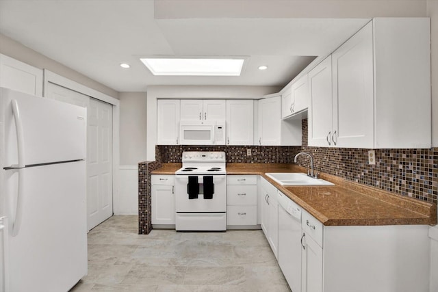 kitchen featuring white cabinets, white appliances, and sink