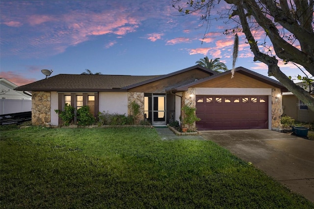 ranch-style home featuring a yard and a garage