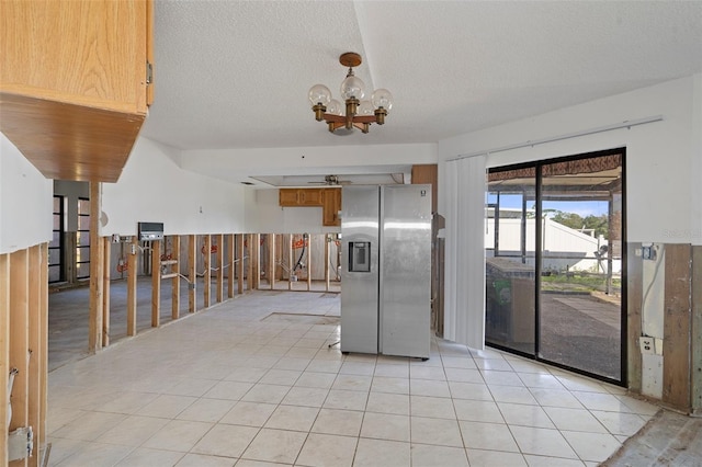 kitchen with stainless steel fridge, light tile patterned flooring, a textured ceiling, and a chandelier