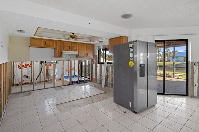 kitchen featuring ceiling fan, a healthy amount of sunlight, stainless steel fridge with ice dispenser, and a textured ceiling