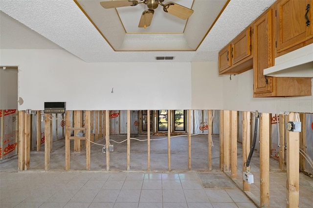 misc room featuring a textured ceiling, ceiling fan, and light tile patterned flooring