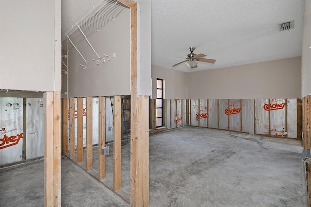 interior space with ceiling fan, concrete flooring, and a textured ceiling