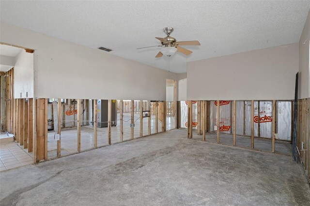 carpeted spare room featuring ceiling fan and a textured ceiling