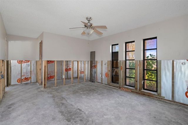 carpeted spare room featuring ceiling fan and a textured ceiling