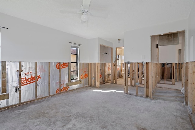 empty room featuring light carpet, a textured ceiling, ceiling fan, and wooden walls